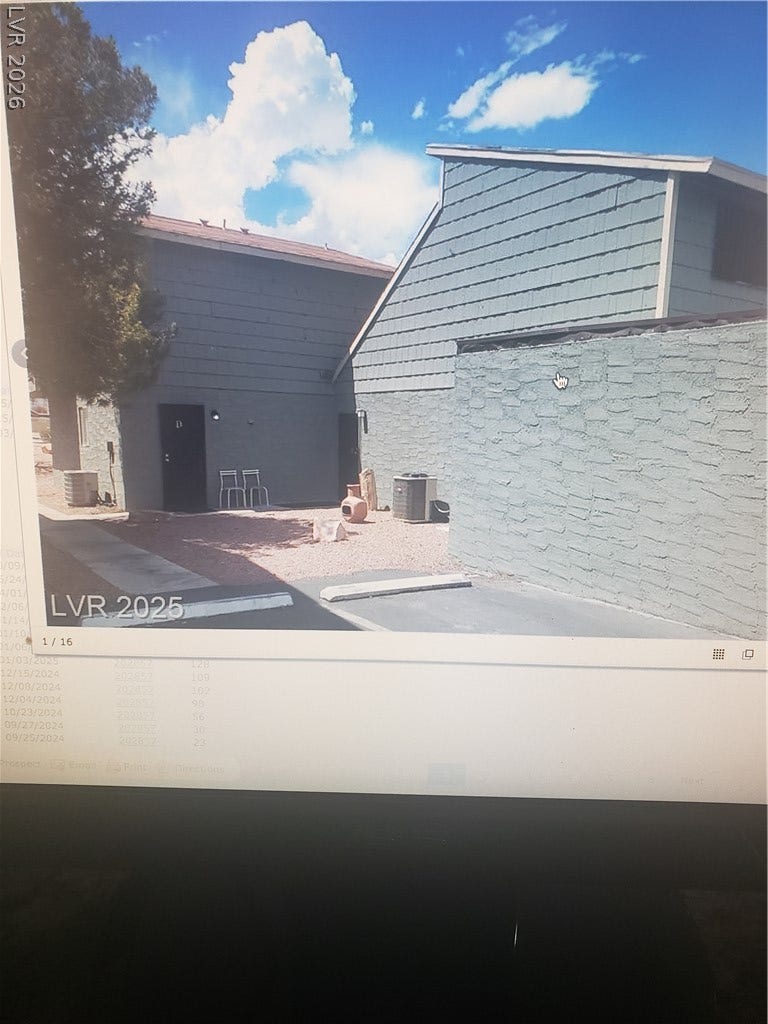 5107 Greene Lane, #L, Las Vegas, NV 89119 A crisp blue sky frames this quiet exterior courtyard with wood siding and stone-textured walls.