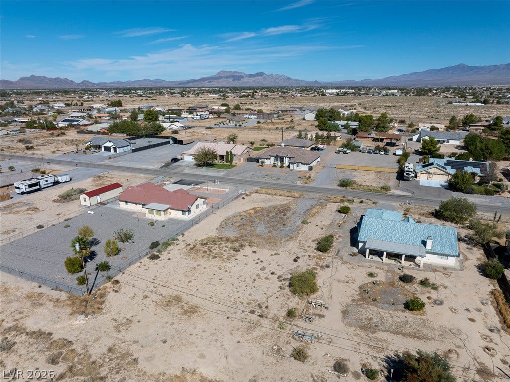 641 E Jaybird Street, Pahrump, NV 89048 An aerial perspective captures a quiet desert neighborhood set against a backdrop of distant mountains.