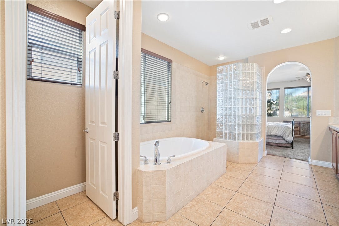 926 Loma Bonita Place, Las Vegas, NV 89138 A tiled archway connects the primary suite to a bathroom with a soaking tub.