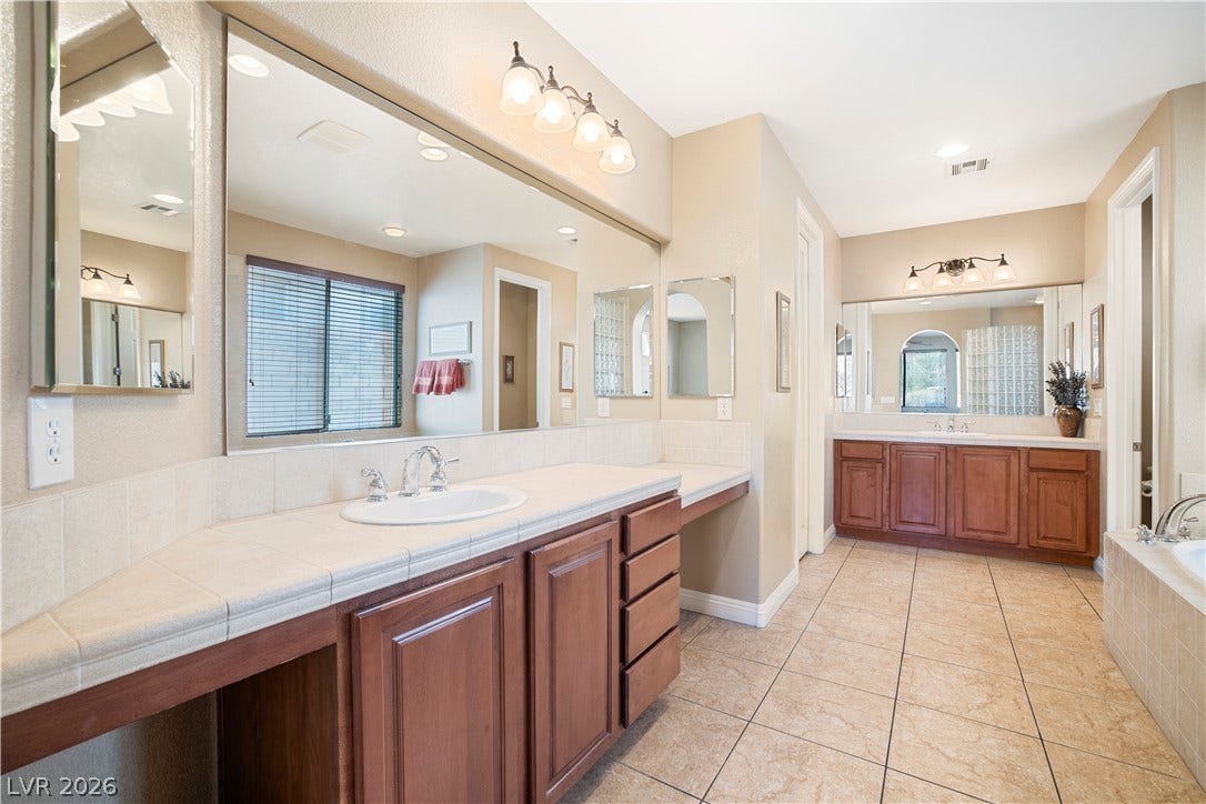 926 Loma Bonita Place, Las Vegas, NV 89138 Ample counter space and classic tile flooring define this spacious primary bathroom suite.