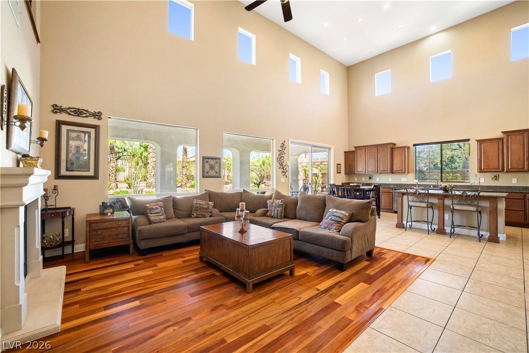 926 Loma Bonita Place, Las Vegas, NV 89138 Soaring ceilings and clerestory windows illuminate this grand open-concept living area with rich hardwood flooring.