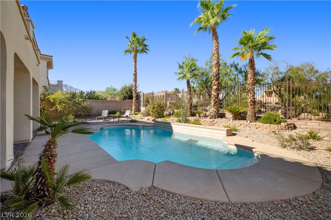 926 Loma Bonita Place, Las Vegas, NV 89138 Towering palm trees frame a sparkling inground pool set within a beautifully landscaped backyard retreat.