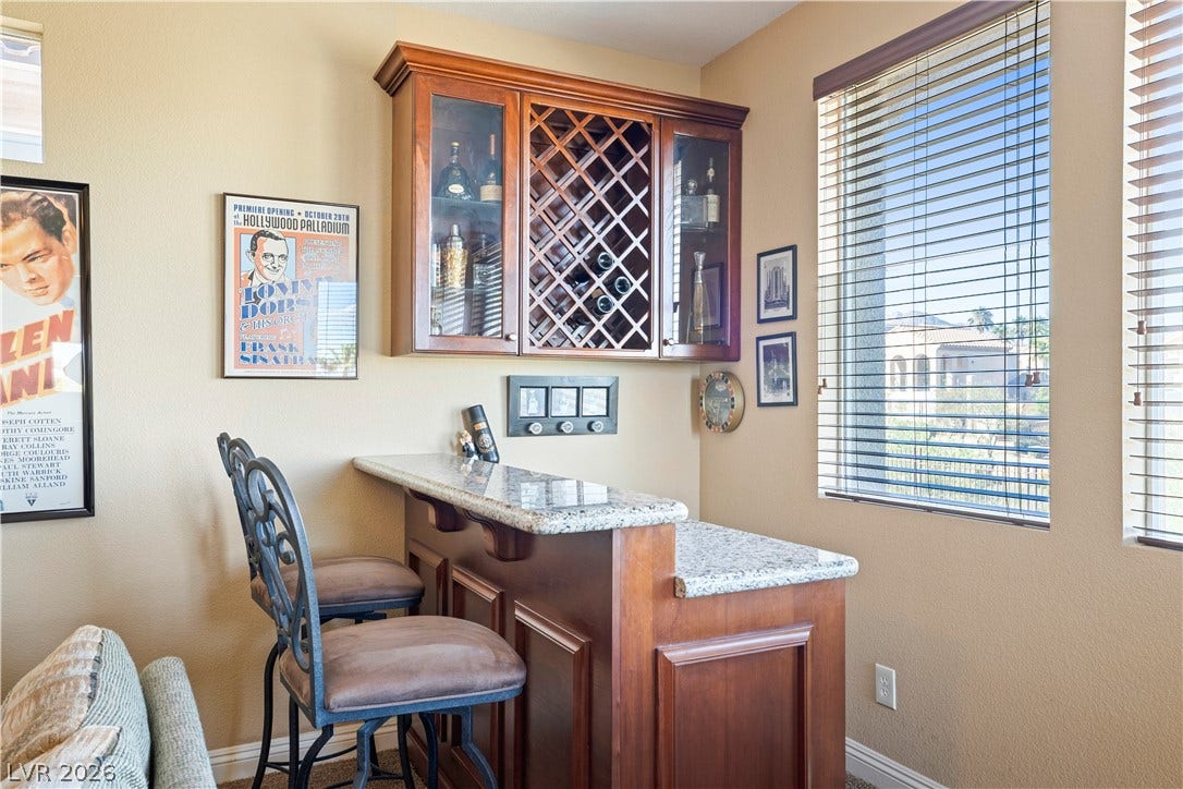 926 Loma Bonita Place, Las Vegas, NV 89138 Rich wood cabinetry and polished granite counters anchor this inviting home bar setup.