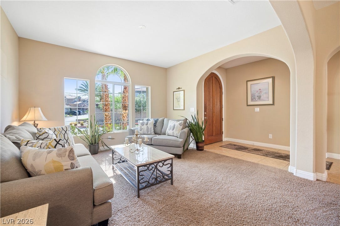 926 Loma Bonita Place, Las Vegas, NV 89138 Sunlight streams through arched windows into a welcoming living space defined by elegant architectural archways.