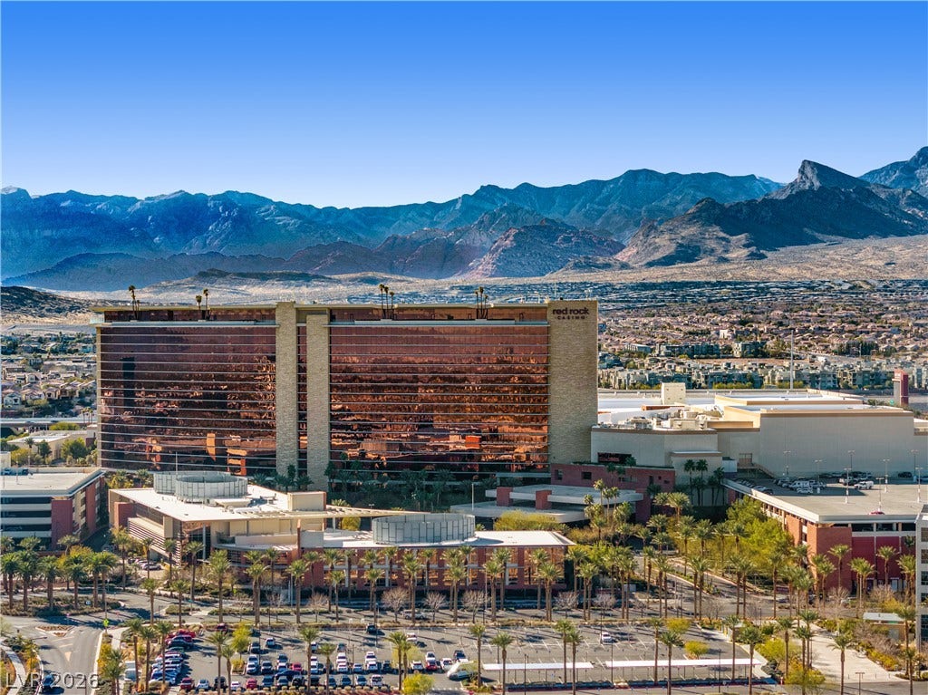 926 Loma Bonita Place, Las Vegas, NV 89138 Majestic mountain ridges rise behind a prominent multistory building overlooking the surrounding neighborhood.