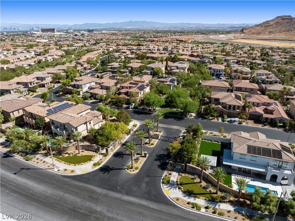 926 Loma Bonita Place, Las Vegas, NV 89138 Gated desert neighborhood offers manicured streets and tile roofs against a distant mountain backdrop.