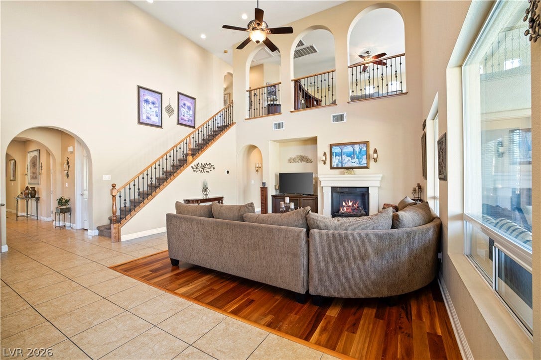 926 Loma Bonita Place, Las Vegas, NV 89138 Dramatic high ceilings and a central fireplace anchor this open, multi-level living area.