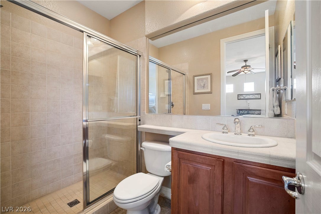 926 Loma Bonita Place, Las Vegas, NV 89138 Tiled walk-in shower and single vanity under a large mirror maximize this bathroom space.