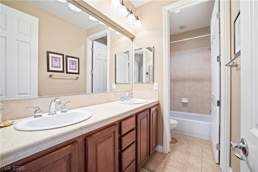 926 Loma Bonita Place, Las Vegas, NV 89138 Double vanities and classic tile flooring enhance this functional bathroom layout.