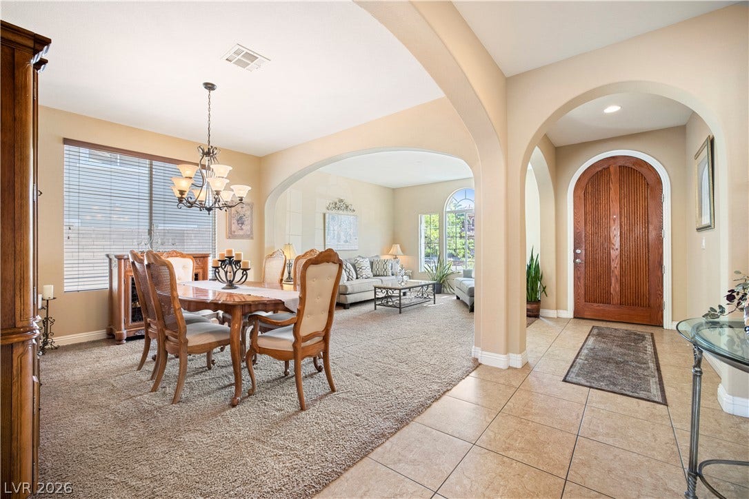 926 Loma Bonita Place, Las Vegas, NV 89138 Graceful arched transitions connect the tiled entryway to a formal dining room with carpet flooring.