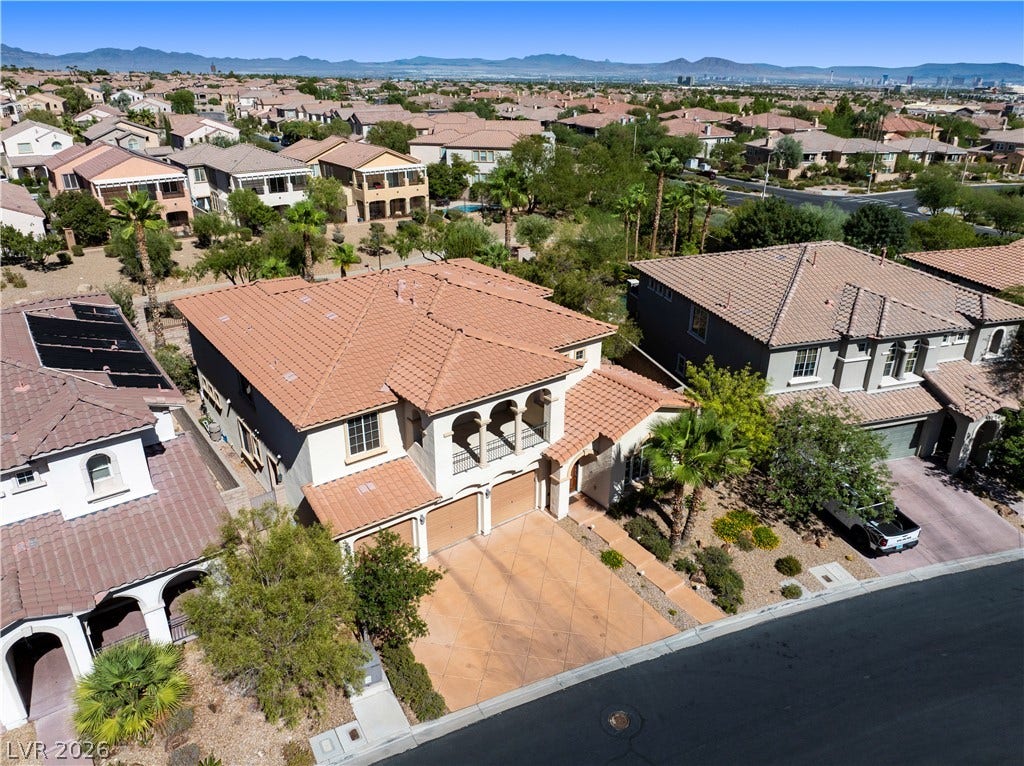 926 Loma Bonita Place, Las Vegas, NV 89138 An elevated perspective showcases the tiled roofline and structured driveway of this suburban home.