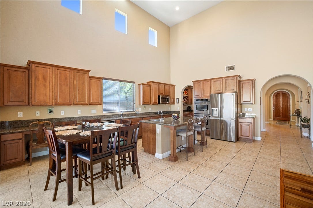 926 Loma Bonita Place, Las Vegas, NV 89138 High ceilings and arched transitions complement the tiled floors in this kitchen and dining area.