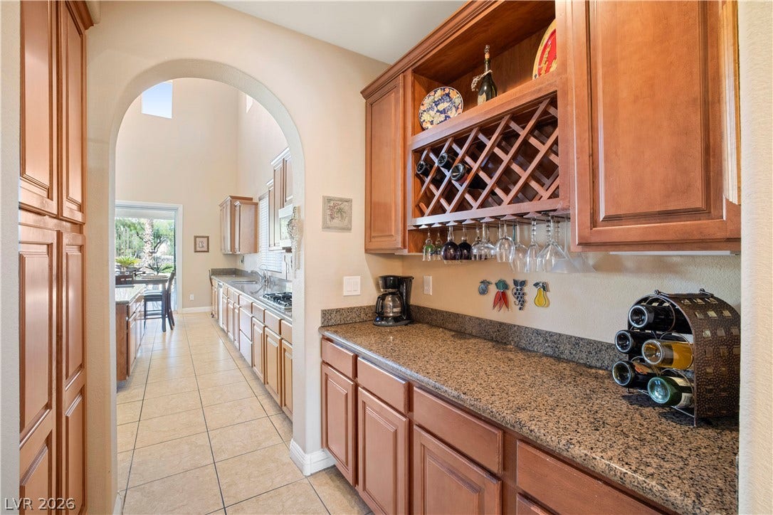 926 Loma Bonita Place, Las Vegas, NV 89138 Rich wood cabinetry and polished granite counters define this convenient butler pantry area.