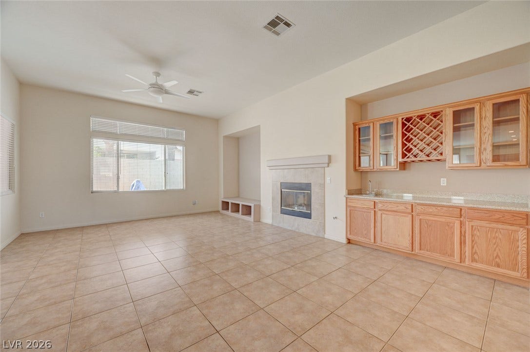 849 Ashford Way, Henderson, NV 89015 A spacious living area offers a cozy fireplace and a convenient wet bar.