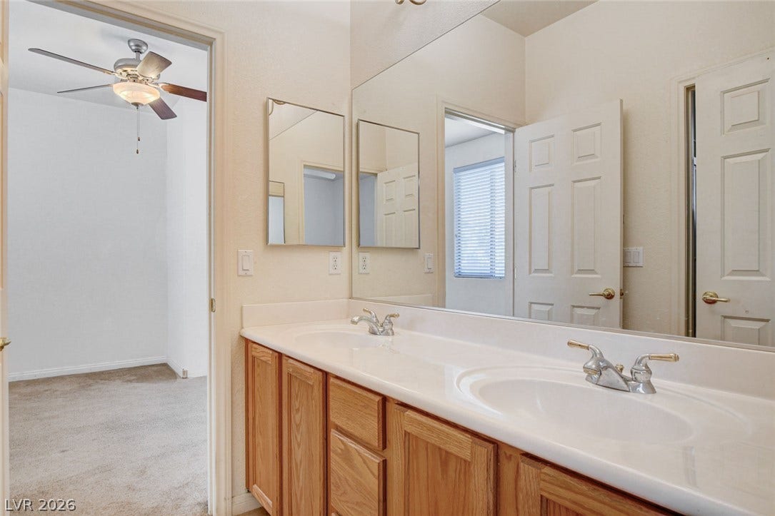 849 Ashford Way, Henderson, NV 89015 Double vanity offers ample space, complementing the adjoining bedroom with a ceiling fan.