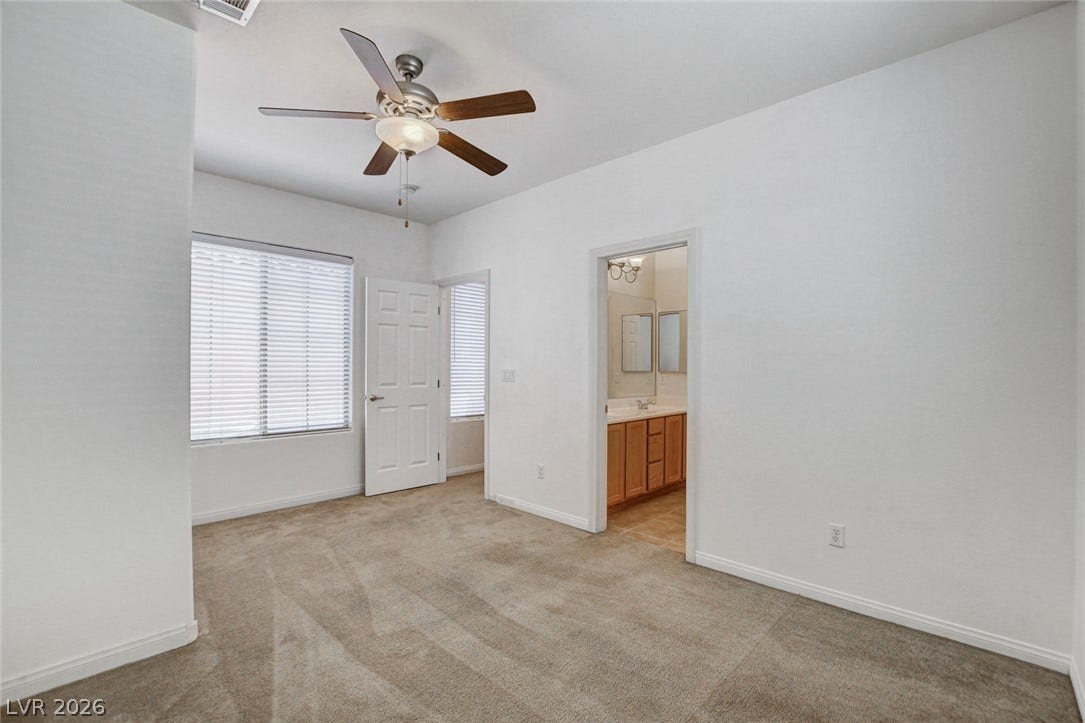 849 Ashford Way, Henderson, NV 89015 A well-proportioned bedroom features carpeted flooring and a convenient ceiling fan for comfort.