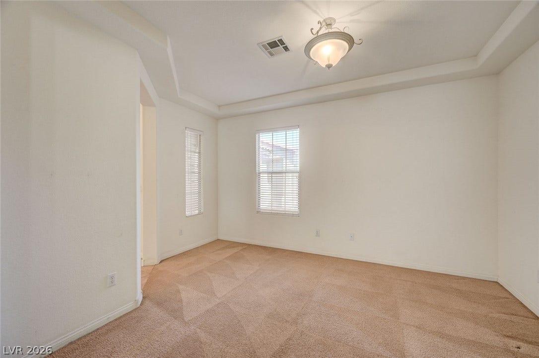 849 Ashford Way, Henderson, NV 89015 A spacious room offers comfortable carpeted flooring and windows that bathe the interior in natural light.