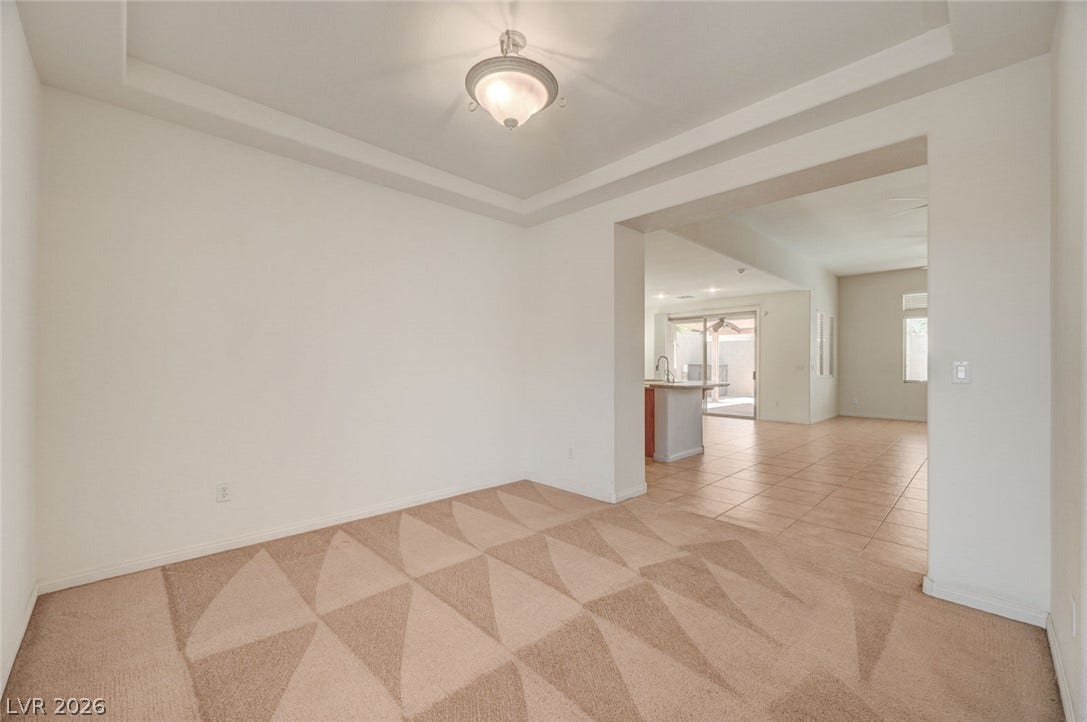 849 Ashford Way, Henderson, NV 89015 A tray ceiling and patterned carpeting define this versatile living space, flowing into a tiled common area.
