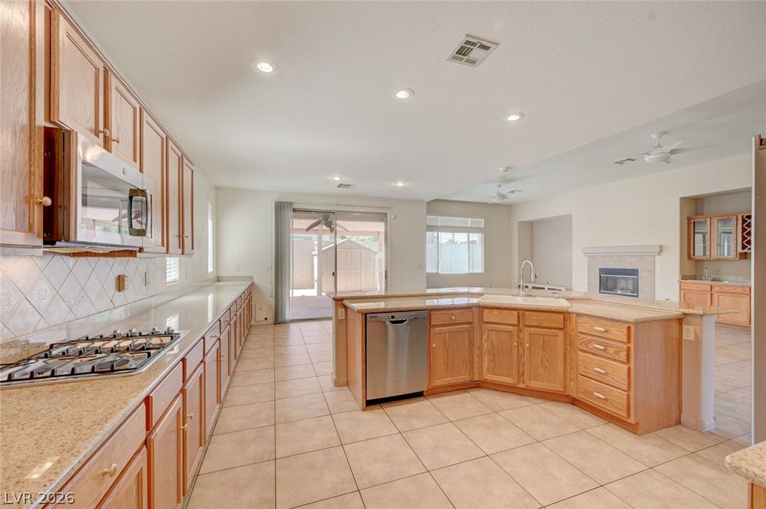 849 Ashford Way, Henderson, NV 89015 Culinary aspirations come to life in this spacious kitchen, featuring extensive countertop space and integrated appliances.