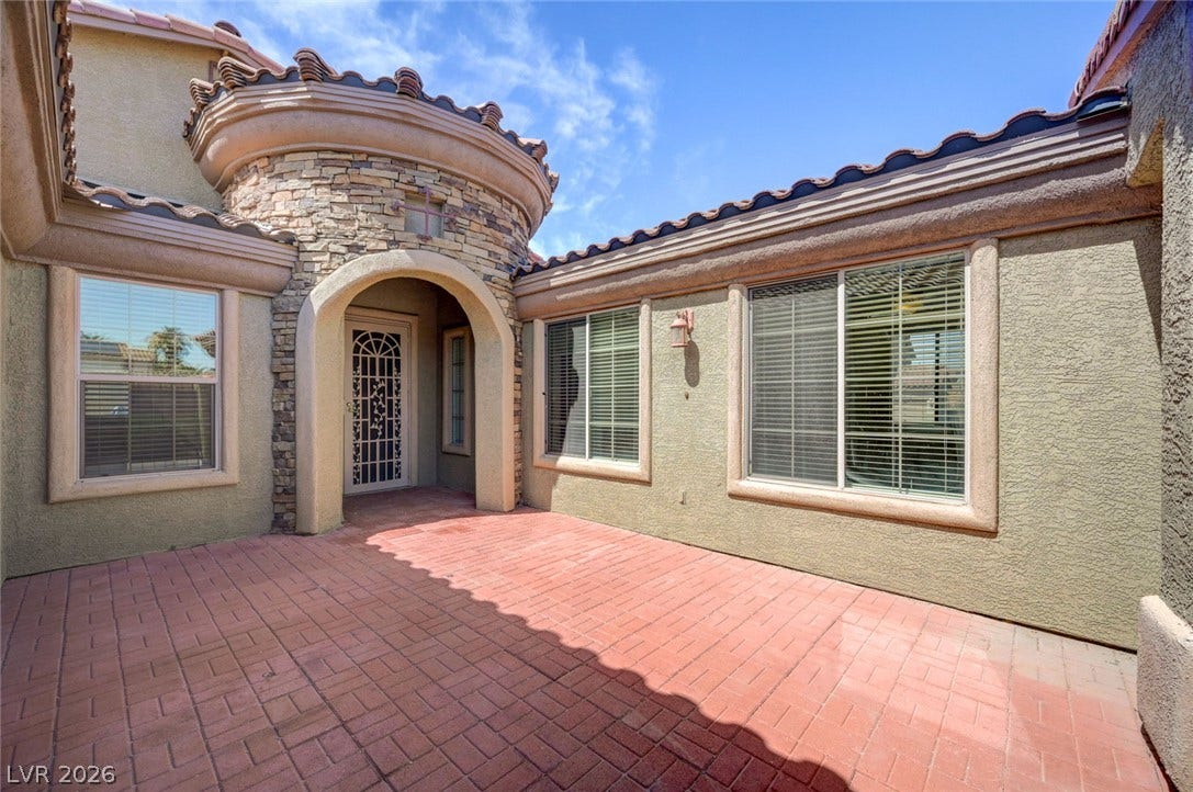 849 Ashford Way, Henderson, NV 89015 A terracotta paved courtyard with a stone-clad turret entry provides a unique and inviting welcome.