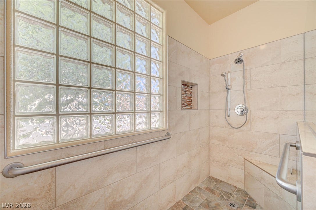 849 Ashford Way, Henderson, NV 89015 A well-appointed shower space offers accessible features and ample natural light from a privacy window.