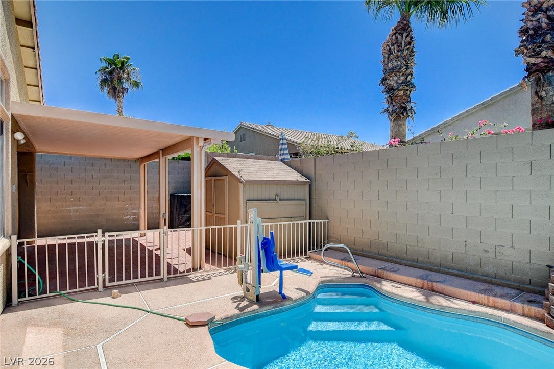 849 Ashford Way, Henderson, NV 89015 An inviting backyard oasis offers a sparkling pool and a covered patio for outdoor enjoyment.