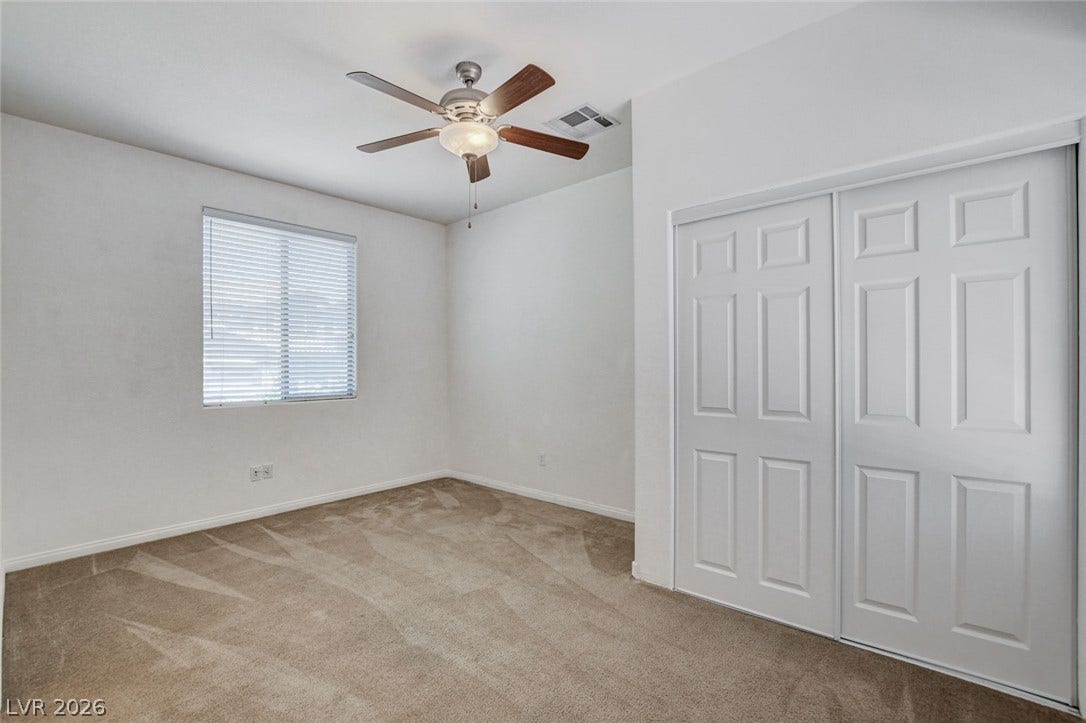 849 Ashford Way, Henderson, NV 89015 A well-lit bedroom features plush carpeting and a convenient sliding closet.