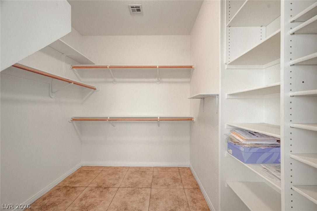 849 Ashford Way, Henderson, NV 89015 Ample shelving and hanging rods create an organized and functional walk-in closet space.