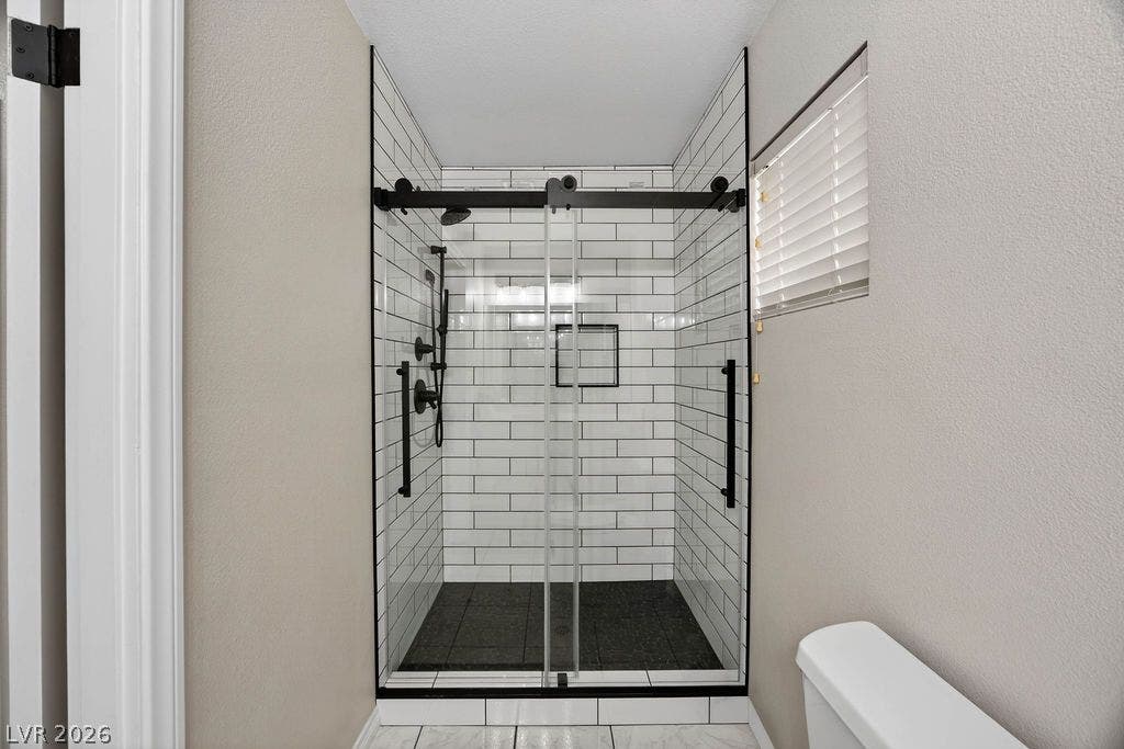 3189 Casanova Circle, Las Vegas, NV 89120 Guest 3/4 bath -A modern walk-in shower highlights classic subway tile and sleek matte black fixtures.