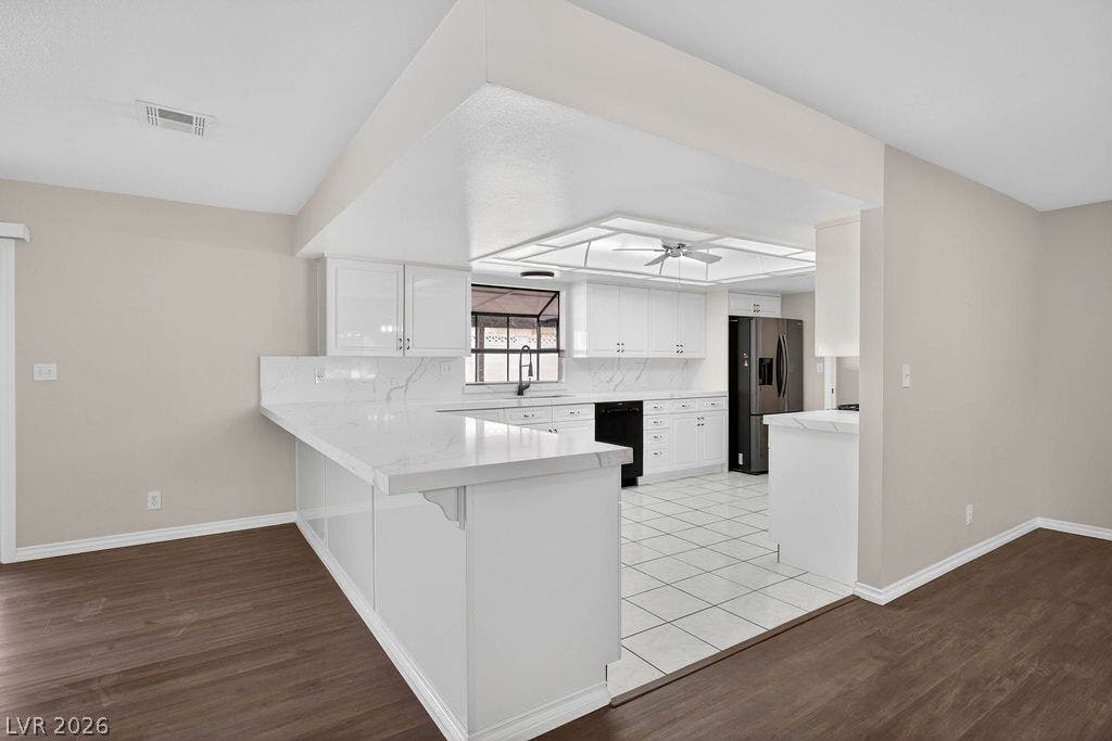 3189 Casanova Circle, Las Vegas, NV 89120 Gleaming stone countertops and pristine cabinetry frame this functional kitchen open to adjacent dining space.