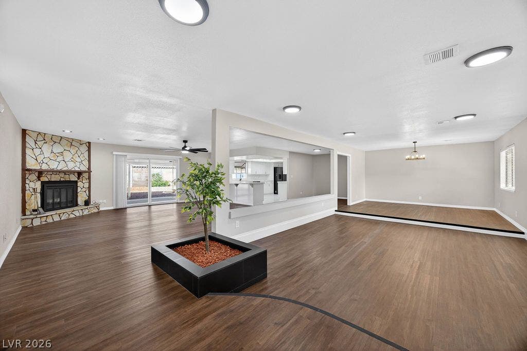 3189 Casanova Circle, Las Vegas, NV 89120 Rich wood-look flooring and a stone fireplace anchor this multi-level open-concept living space.