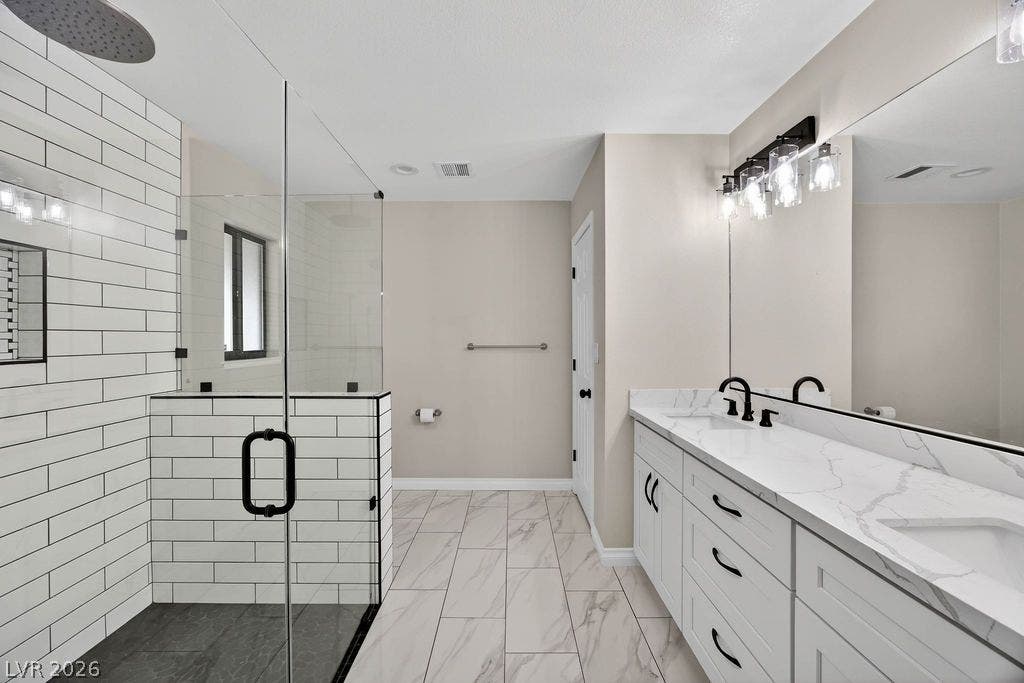 3189 Casanova Circle, Las Vegas, NV 89120 Marble-look tile floors and a glass-enclosed shower anchor this contemporary bathroom layout.