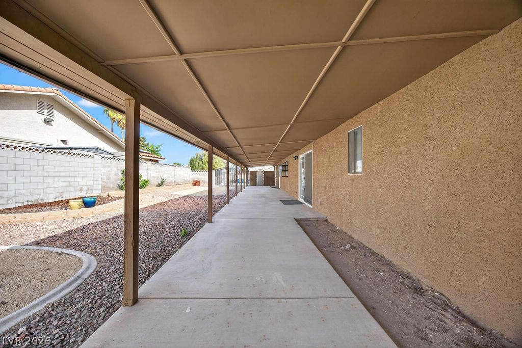 3189 Casanova Circle, Las Vegas, NV 89120 An expansive covered concrete patio stretches alongside the stucco exterior wall.