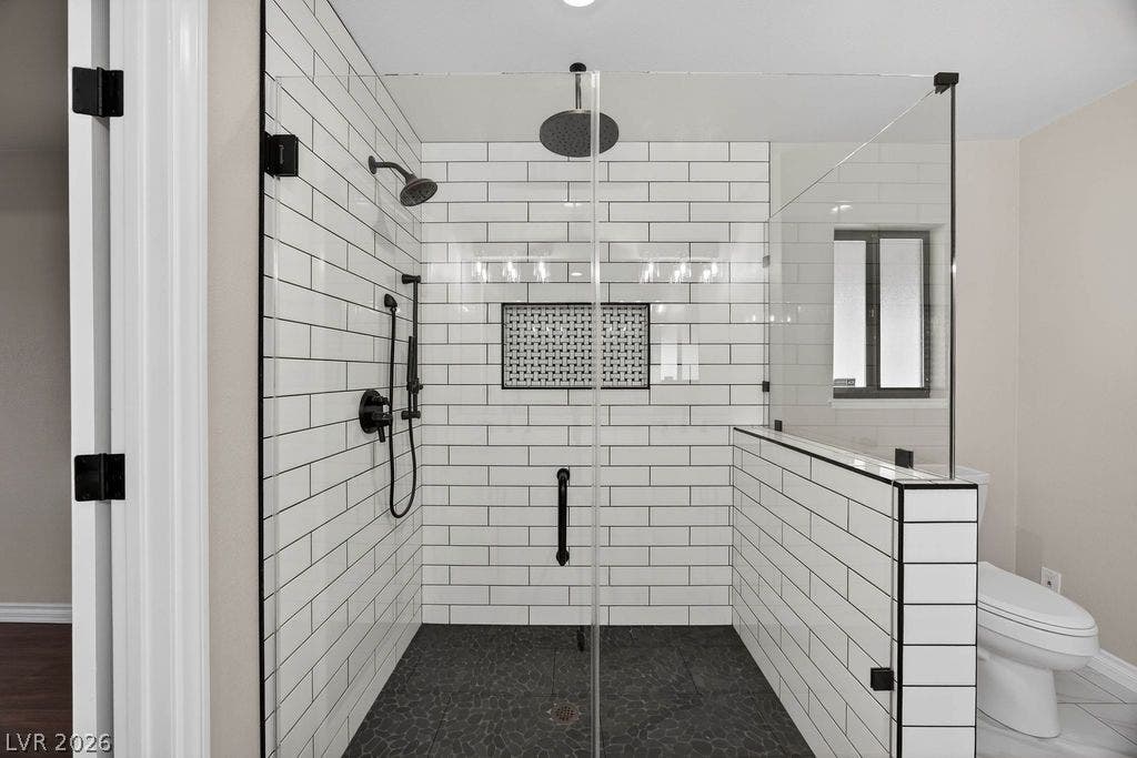 3189 Casanova Circle, Las Vegas, NV 89120 White subway tile wall surrounds complement a modern walk-in shower with dark stone flooring.
