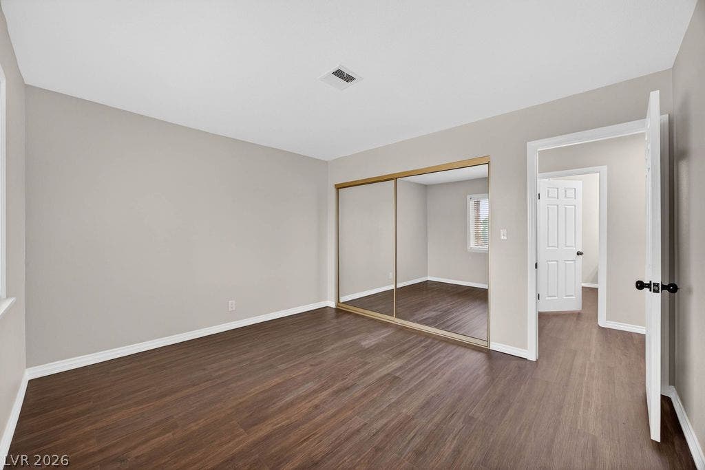 3189 Casanova Circle, Las Vegas, NV 89120 BED #3 Rich wood-inspired flooring and mirrored closet doors define this versatile, light-filled bedroom space.