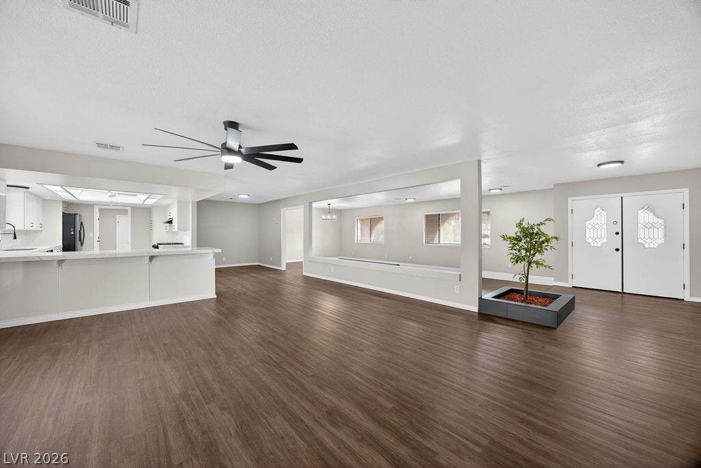 3189 Casanova Circle, Las Vegas, NV 89120 Rich wood flooring anchors this sprawling open-concept living area with clean architectural lines.