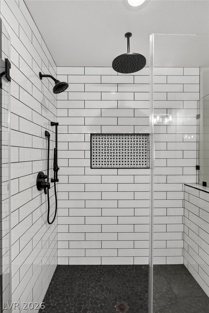 3189 Casanova Circle, Las Vegas, NV 89120 Crisp subway tile surrounds a walk-in shower featuring a rain showerhead and inset niche.