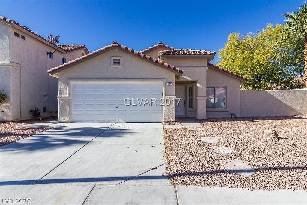 6329 Monarch Creek Street, Las Vegas, NV 89130 Classic Mediterranean styling defines this single-level home with a tile roof and integrated garage.