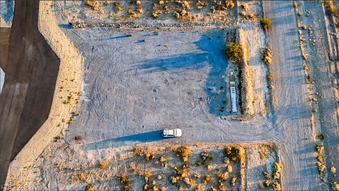 An aerial perspective reveals a cleared lot ready for development in a desert environment.
