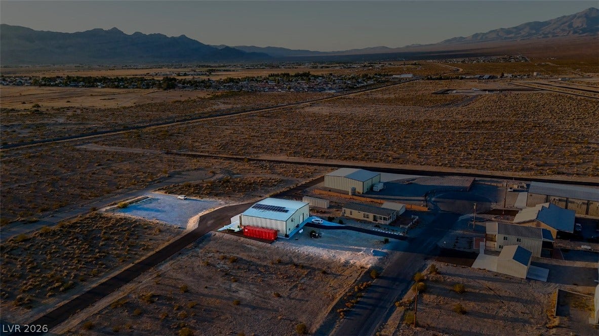 Rugged desert terrain frames this expansive property with sweeping mountain views and solar panels.