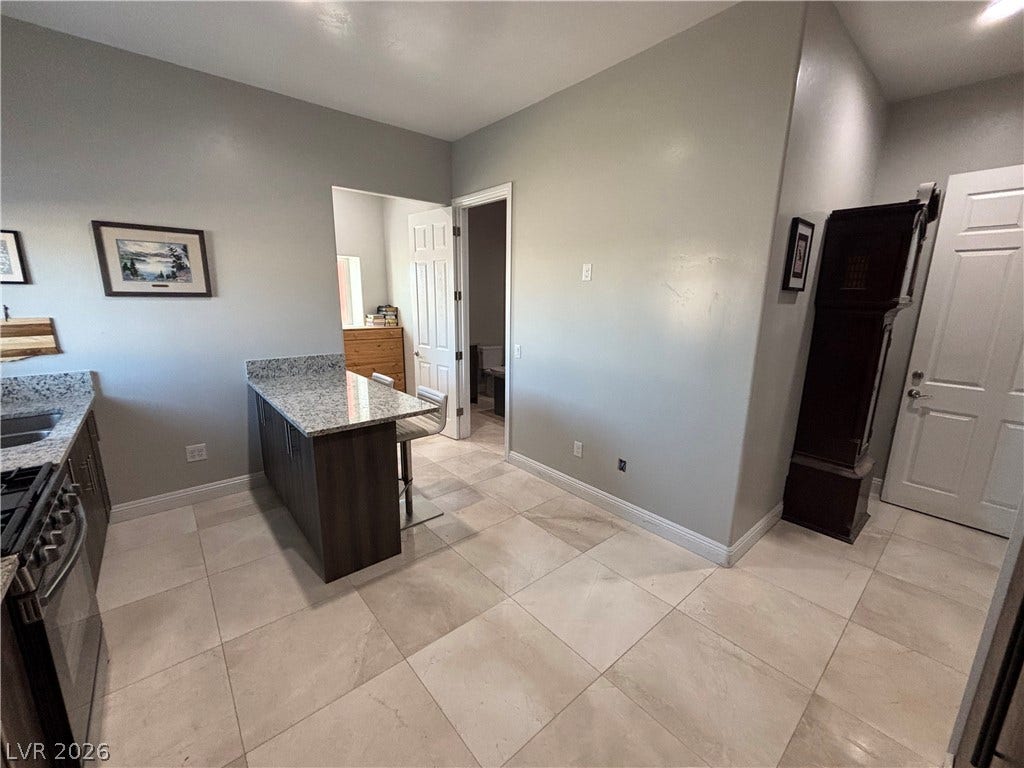 Polished tile flooring and granite counters define this functional kitchen area.