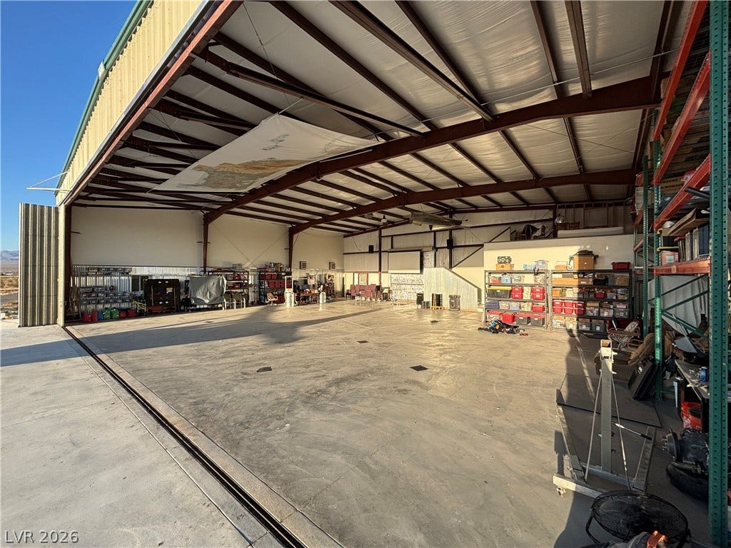 A spacious aircraft hangar features high metal ceilings and durable concrete flooring.