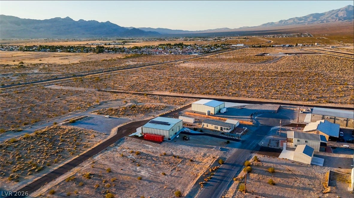 Dramatic mountain ranges frame the wide desert horizon surrounding this expansive multi-structure property.