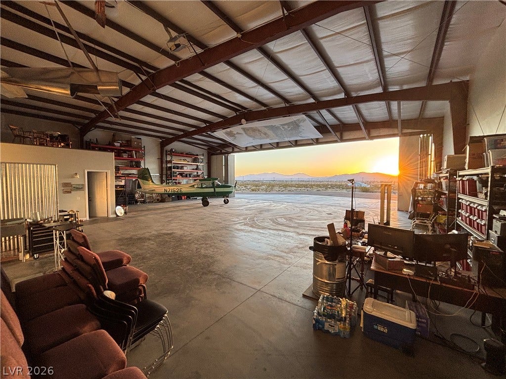 Industrial steel beams and concrete floors define this expansive workspace framing beautiful sunset views.