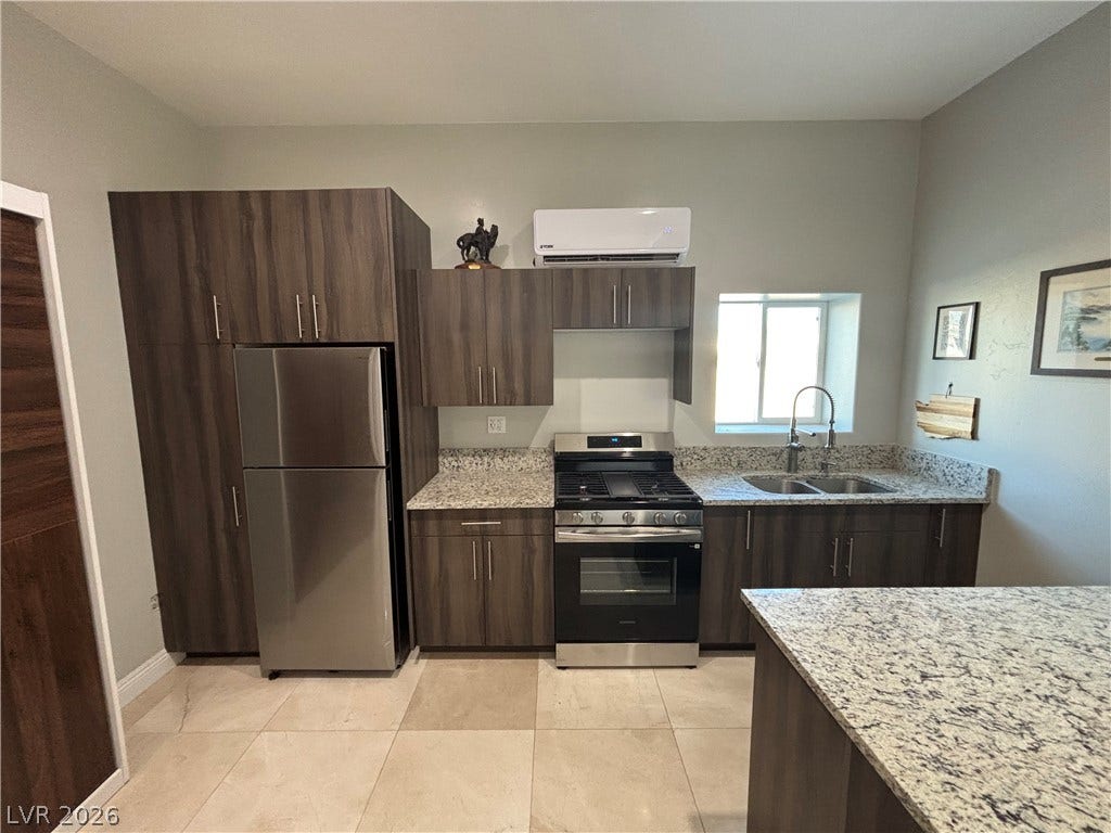 Richly toned cabinetry and speckled stone countertops define this modern, functional cooking space.