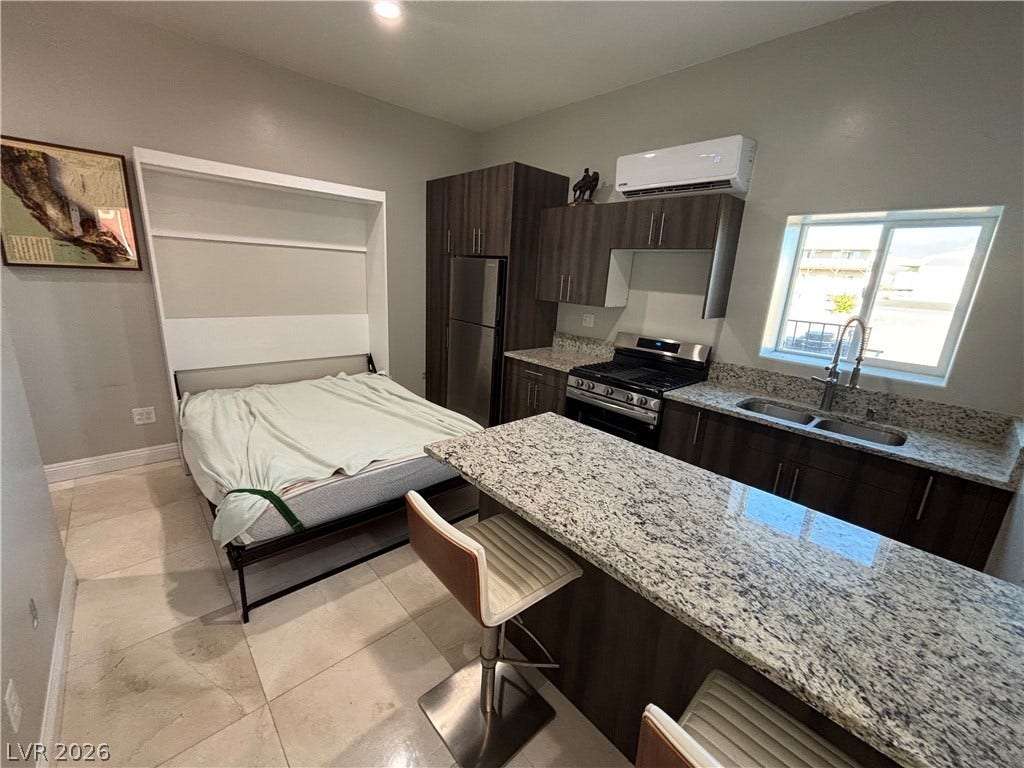 Granite countertops and clean tile flooring define this efficient studio living area.