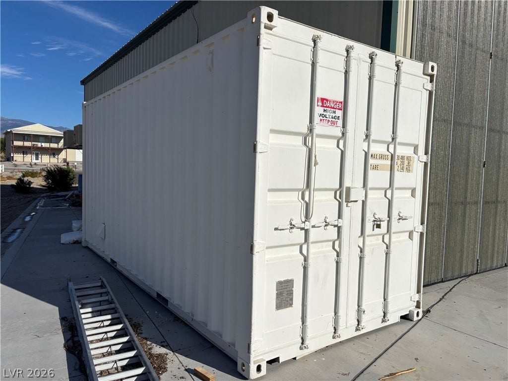 Detached metal storage container offers durable utility space adjacent to the main building.
