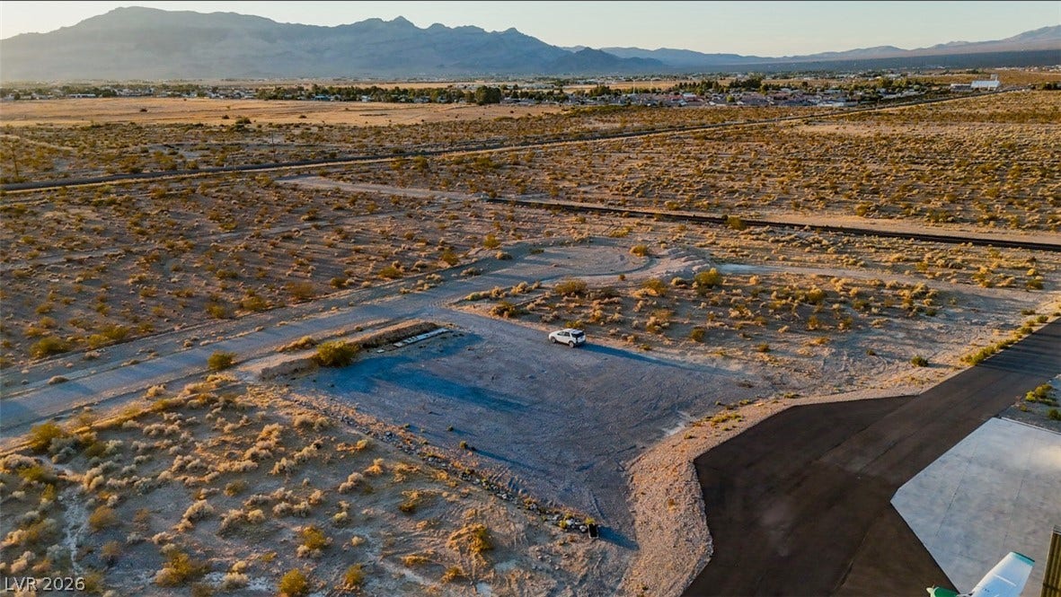 Vast desert parcels sit positioned beneath a backdrop of distant mountain ranges.