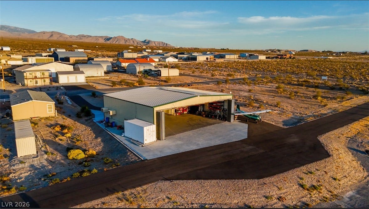 An expansive airplane hangar provides immediate access to the paved taxiway and runway network.