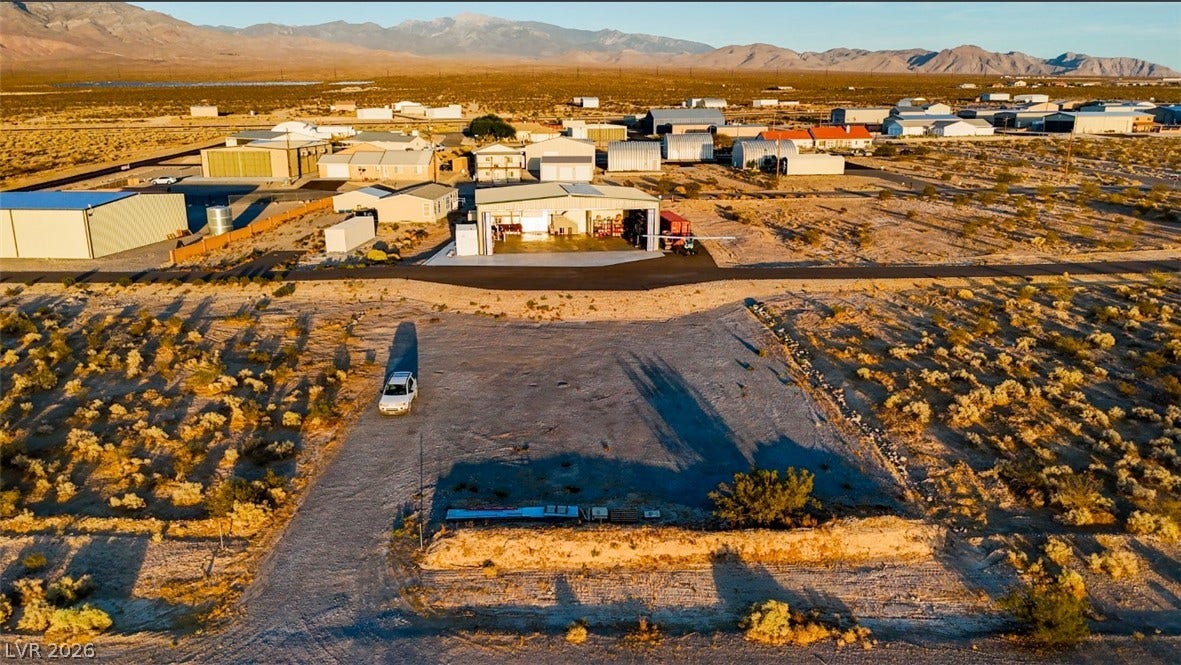 Rugged desert terrain frames this expansive property featuring a level building site and mountain backdrops.
